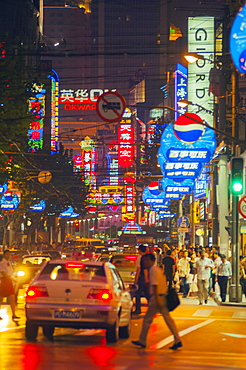 Shoppers in neon lit streets, Shanghai, China, Asia