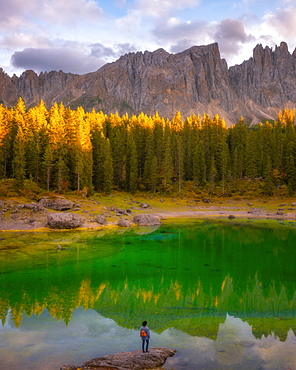 Young man observing the beauty of Lago Di Carezza at sunset, Dolomites, Italy, Europe