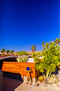 View of beautiful desert home and woman getting a tan, Palm Springs, California, United States of America, North America