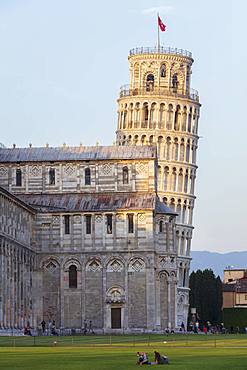 People relaxing on the lawns of the Campo dei Miracoli with the Cathedral and Leaning Tower behind, UNESCO World Heritage Site, Pisa, Tuscany, Italy, Europe