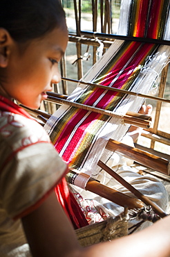 A little girl learns the art of weaving on a hand loom, Chittangong Hill Tracts region, Bangladesh, Asia