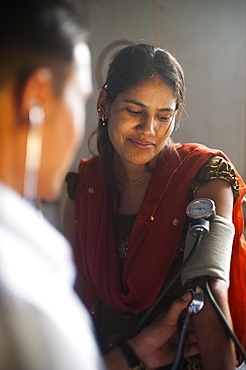 A doctor takes a woman's blood pressure in a hospital in Nepal, Asia