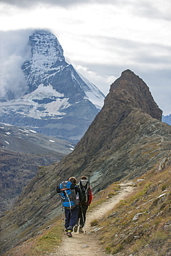 Hiking a trail in the Swiss Alps near Zermatt with a view of The Matterhorn in the distance, Zermatt, Valais, Switzerland, Europe