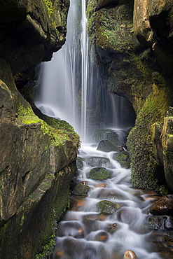 Hidden waterfall in the cliffs behind Singing Sands Beach, Cleadale, The Isle of Eigg, Small Isles, Inner Hebrides, Scotland, United Kingdom, Europe