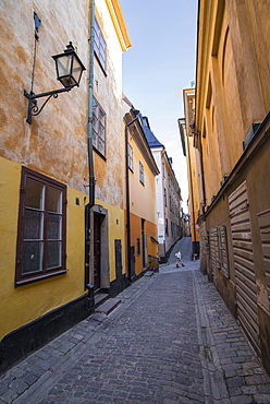 A pedestrian walks the streets of Stockholm's colorful and historic Gamla Stan district, Stockholm, Sweden, Scandinavia, Europe