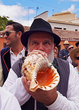 Man blowing conch shell, Romeria de San Benito de Abad, traditional street party, San Cristobal de La Laguna, Tenerife Island, Canary Islands, Spain, Europe