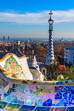 Park Guell houses and mosaic tiles at Parc Guell by Antoni Gaudi, UNESCO World Heritage Site, with views over the city to the sea, Barcelona, Catalonia, Spain, Europe