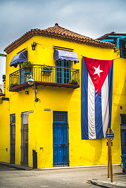 Huge Cuban flag on yellow building in Havana, La Habana (Havana), Cuba, West Indies, Caribbean, Central America