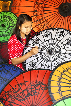 Young lady decorates colourful parasols in Bagan (Pagan), Myanmar (Burma), Asia