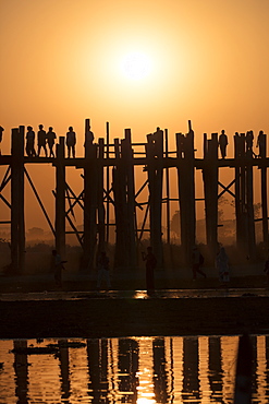 Sunset at U Bein bridge, oldest and longest teak bridge in the world, across Lake Taungthaman, Amarapura, Myanmar (Burma), Asia