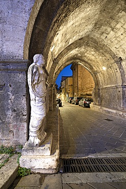 Roman toga-wearing statue from the forum area, Bell tower and arch of St. Peter, Isernia, Molise, Italy