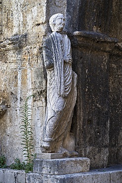 Roman toga-wearing statue from the forum area, Bell tower and arch of St. Peter, Isernia, Molise, Italy