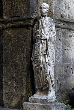 Roman toga-wearing statue from the forum area, Bell tower and arch of St. Peter, Isernia, Molise, Italy