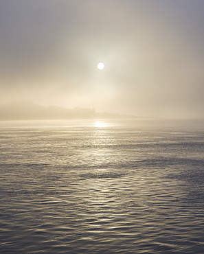 The sun shines through heavy fog on the sea front at Exmouth, Devon, England, United Kingdom, Europe