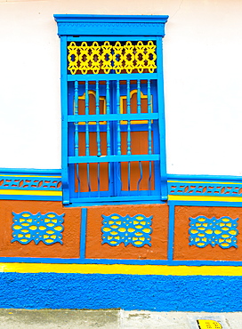 The facade of a colourful building covered in traditional local tiles, in the picturesque town of Guatape, Colombia, South America