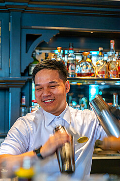 Bar tender with cocktail shakers making Singapore slings, Long Bar, Raffles Hotel, Singapore, Southeast Asia, Asia