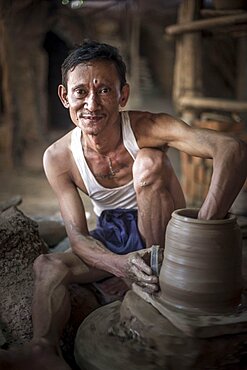 Portrait of a potter in an Oh Bo pottery shed, Twante, near Yangon, Myanmar, Burma