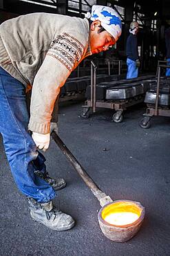 Waiting for the right temperature. Takahiro Koizumi carries molten iron with spoon to pour it into the mold, to make a iron teapot or tetsubin, nanbu tekki, Workshop of Koizumi family,craftsmen since 1659, Morioka, Iwate Prefecture, Japan