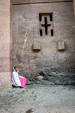 A young girl sitting against the walls of Bet Medhane Alem (Church of the World Savior) in Lalibela, Ethiopia