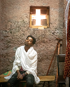 A man rests on a bench inside the rock hewn monolithic church of Bet Maryam (Church of St. Mary) in Lalibela, Ethiopia