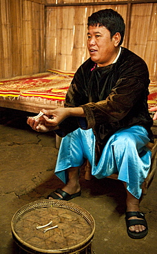 Local shaman explaining how he interprets chicken bones that people bring to him for guidance, in the Lisu village of Sridongyen in rural Chiang Mai Province, Thailand.