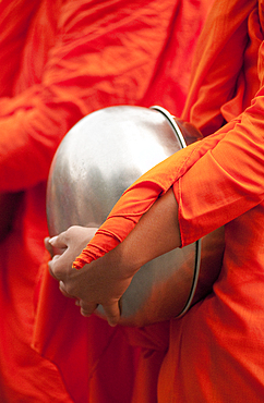 Buddhist monk with bowl during morning procession for offerings of food; Huay Kaew area, Chiang Mai, Thailand.