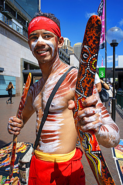 Australian Aboriginal dressed man selling boomerangs in The Rocks area at Circular Quay in Sydney New South Wales, Australia