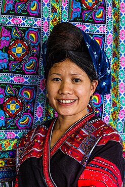 A woman of the Red Yao ethnic minority sells traditional hand-woven fabrics in Ping'an, China.