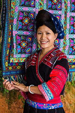 A woman of the Red Yao ethnic minority sells traditional hand-woven fabrics in Ping'an, China.