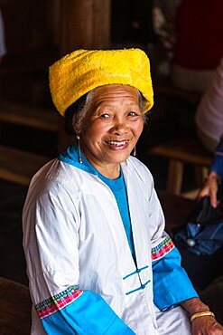 A portrait of an older woman of the Zhuang ethnic minority group in traditional attire at Longshen, China.