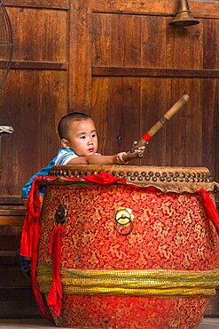 A young Yao boy beats a traditional drum before a cultural performance in Huangluo, China.