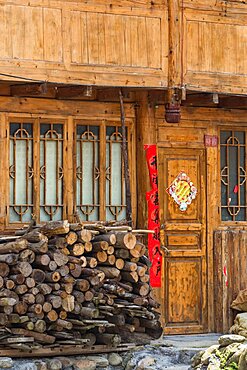 A pile of firewood stacked in front of a traditional house in the Red Yao village of Huangluo, China.