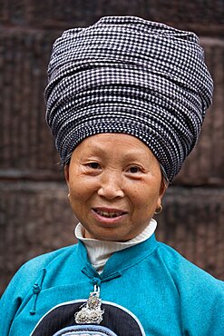 A woman in the traditional attire of the Tujia ethnic minority in Fenghuang, China.