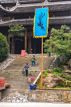 Workers carrying buckets on yokes for removing debris from a building under renovation in Furong, China.