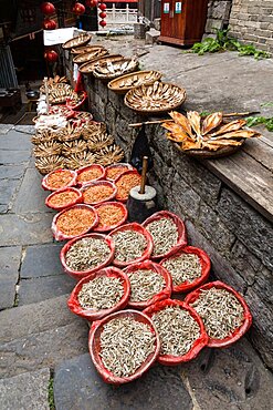 Baskets of dried fish and shrimp for sale on the street in the ancient town of Furong, China.