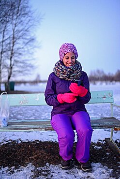 Young woman using mobile telephone in winter environment