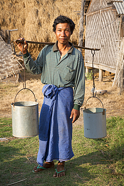 Man carrying pannier for water, Yay Kyi village, Mandalay, Myanmar, (Burma)