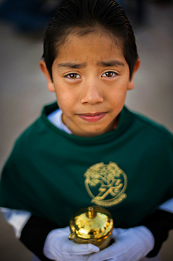 Other participants include adults and children in various dress which include altar boys, Nazarenes,