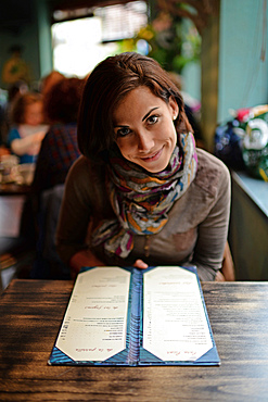 Young attractive woman looking at menu in a cafe