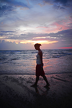 Young woman enjoying sunset at Hikkaduwa beach, Sri Lanka