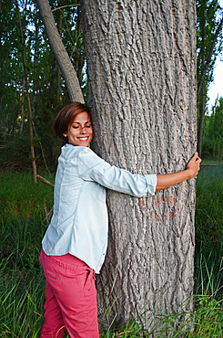 Young attractive woman hugging a tree in nature