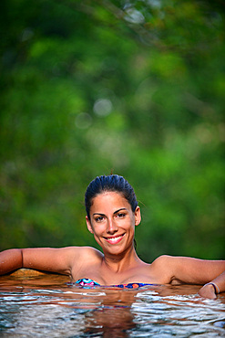 Young attractive woman enjoying a bath in the infinity edge swimming pool at The Dutch House, Galle, Sri Lanka