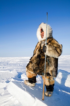 Man looks for animals to hunt in Gojahaven, an Inuit settlement in the far north of Canada.