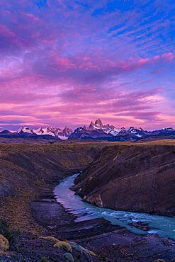 Colorful clouds in the predawn sky over Mount Fitz Roy and the Rio del las Vueltas.  Los Glaciares National Park near El Chalten, Argentina.  A UNESCO World Heritage Site in the Patagonia region of South America.