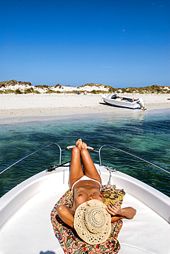 Woman relaxing on yacht in Espalmador, a small island located in the North of Formentera, Balearic Islands, Spain