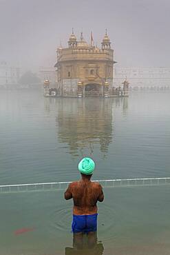 pilgrim bathing in the sacred pool Amrit Sarovar, Golden temple, Amritsar, Punjab, India