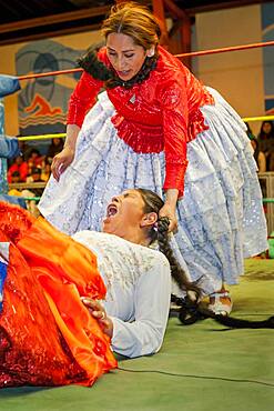 Lucha Libre. Combat between Dina with orange skirt and Benita la Intocable , cholitas females wrestlers ,Sports center La Ceja, El Alto, La Paz, Bolivia