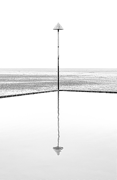 A groyne marker reflected in the tidal pool at low tide, Leigh on Sea, Essex, England, United Kingdom, Europe