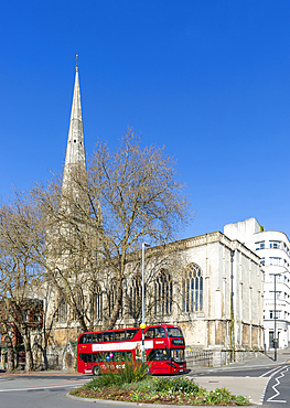 Red double-decker bus passing Church of Saint Nicholas, Baldwin Street, city centre of Bristol, England, UK built 1769