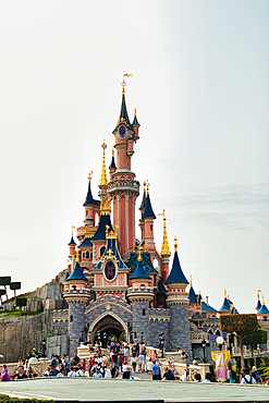 Full shot of Sleeping Beauty castle in Disneyland Paris, crowded with people on a sunny day at Disneyland Paris, France.